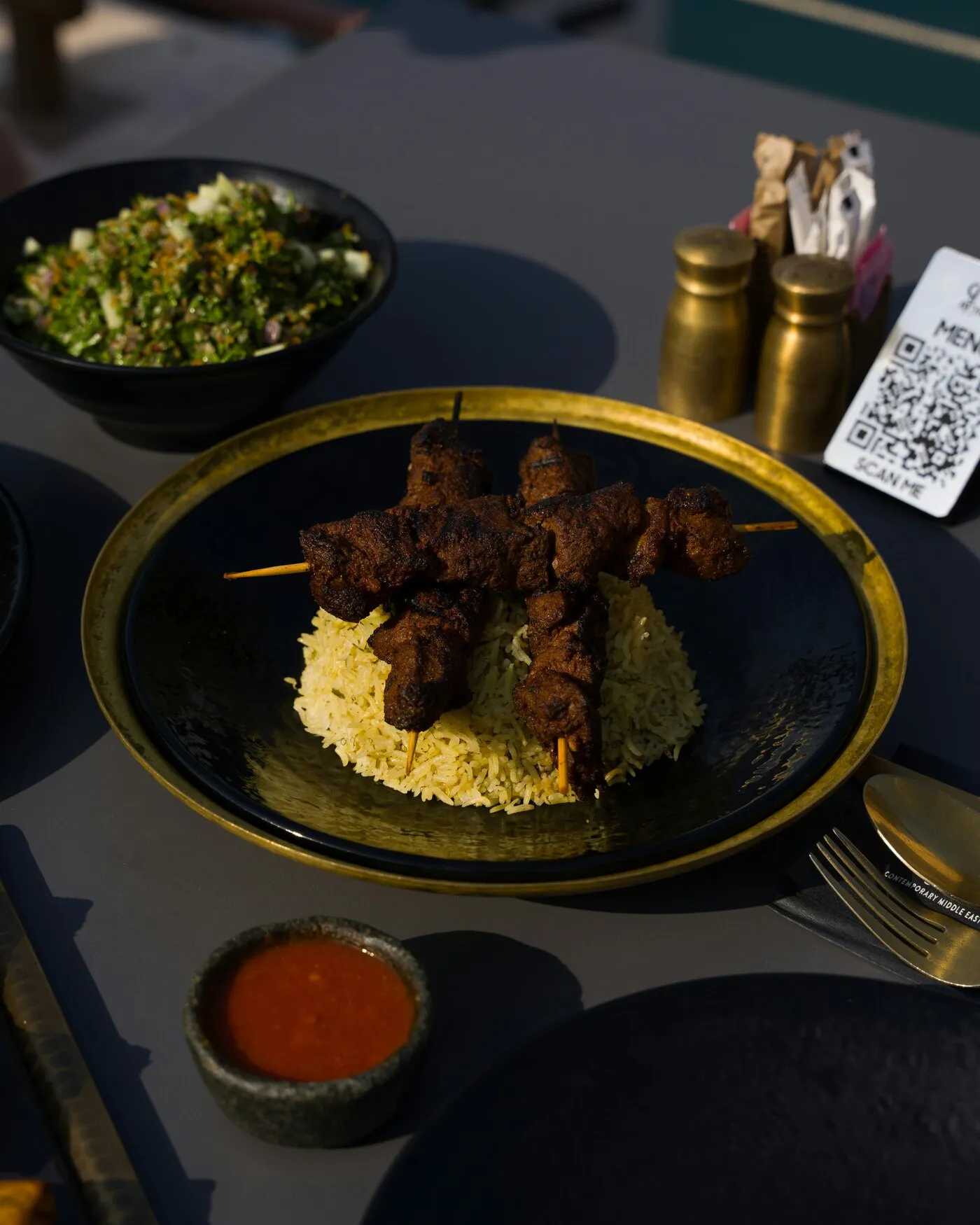Plat servi en terrasse, avec un QR Code de menu posé sur la table